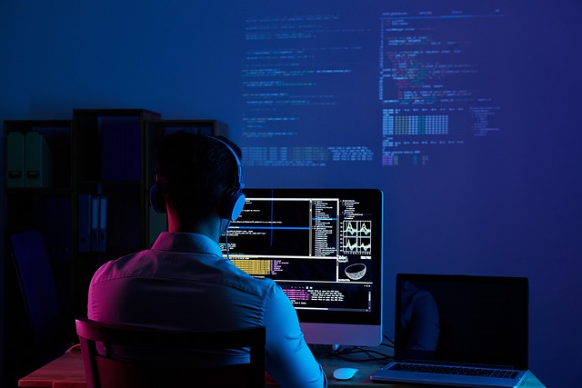 Software developer working at a laptop with code on screen